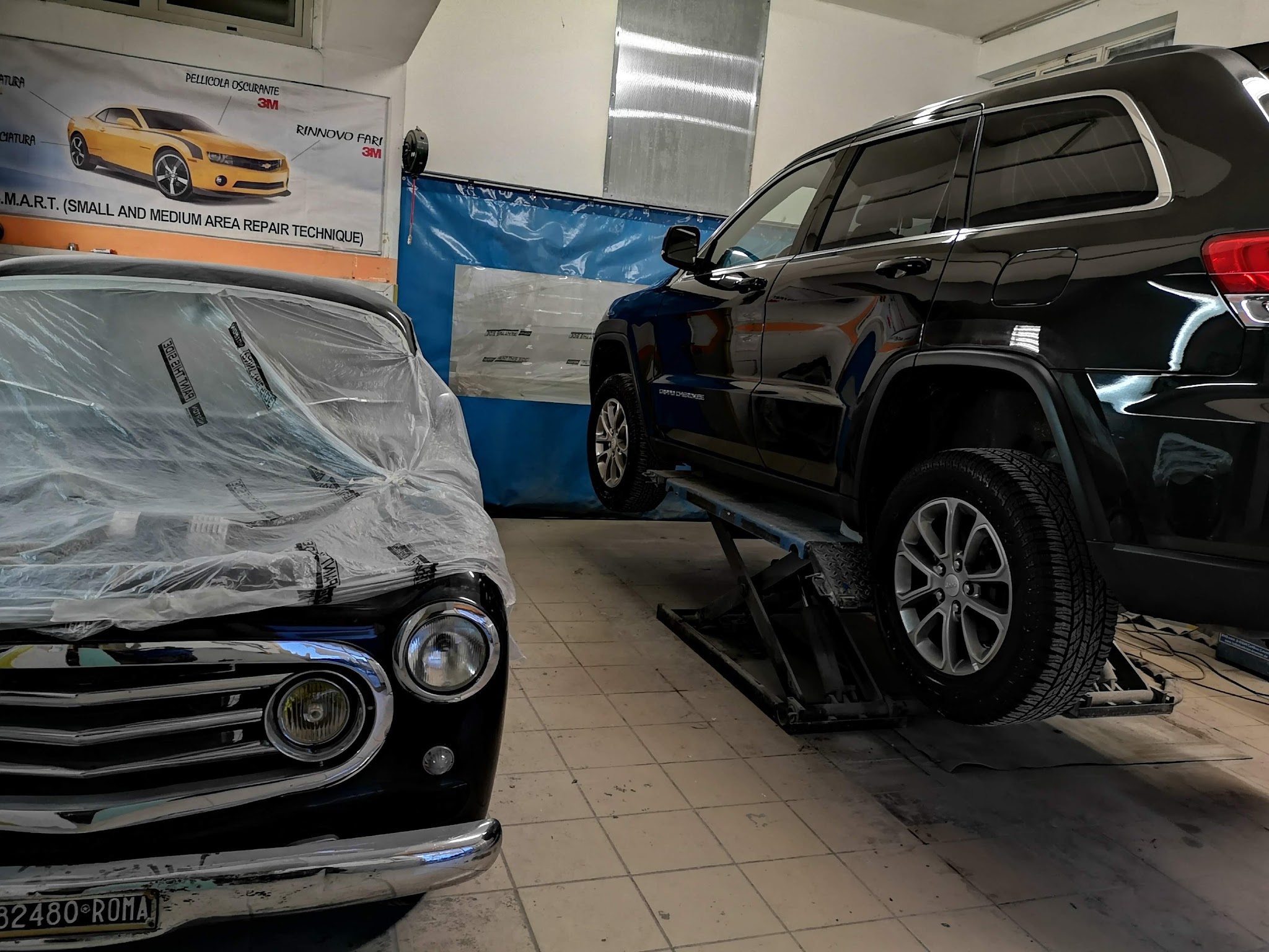 Auto classica e SUV sul ponte nella micro carrozzeria